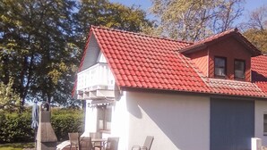 A house with a red roof, a garage, and a patio with chairs. - Haus Caroline by Interhome (Plau am See)