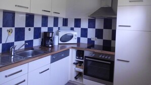 A compact kitchen with white cabinets, a microwave, a coffee maker, and a dishwasher. - Haus Caroline by Interhome (Plau am See)