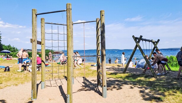 A beach with a wooden swing set and a netted play area. - Haus Caroline by Interhome (Plau am See)