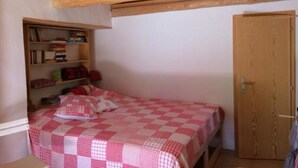 Una camera da letto con un letto, una libreria e una porta in legno.