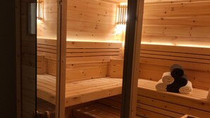 Een houten sauna met banken en een bank met een handdoek.