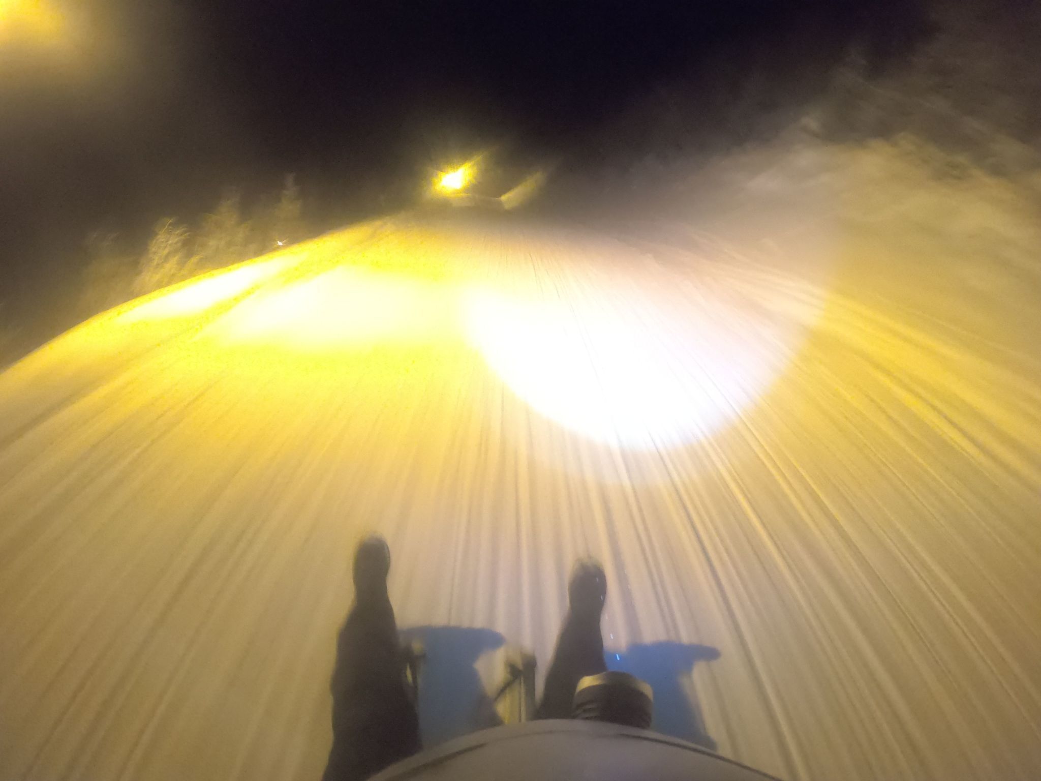 Iemand ligt op een bed met een felle lichtbron erboven, mogelijk een plafondlamp.