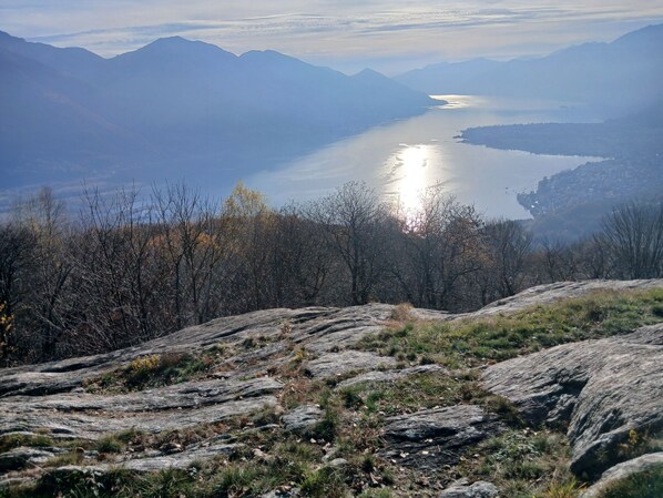 Un paisaje montañoso con un lago y vista de un pueblo a lo lejos.