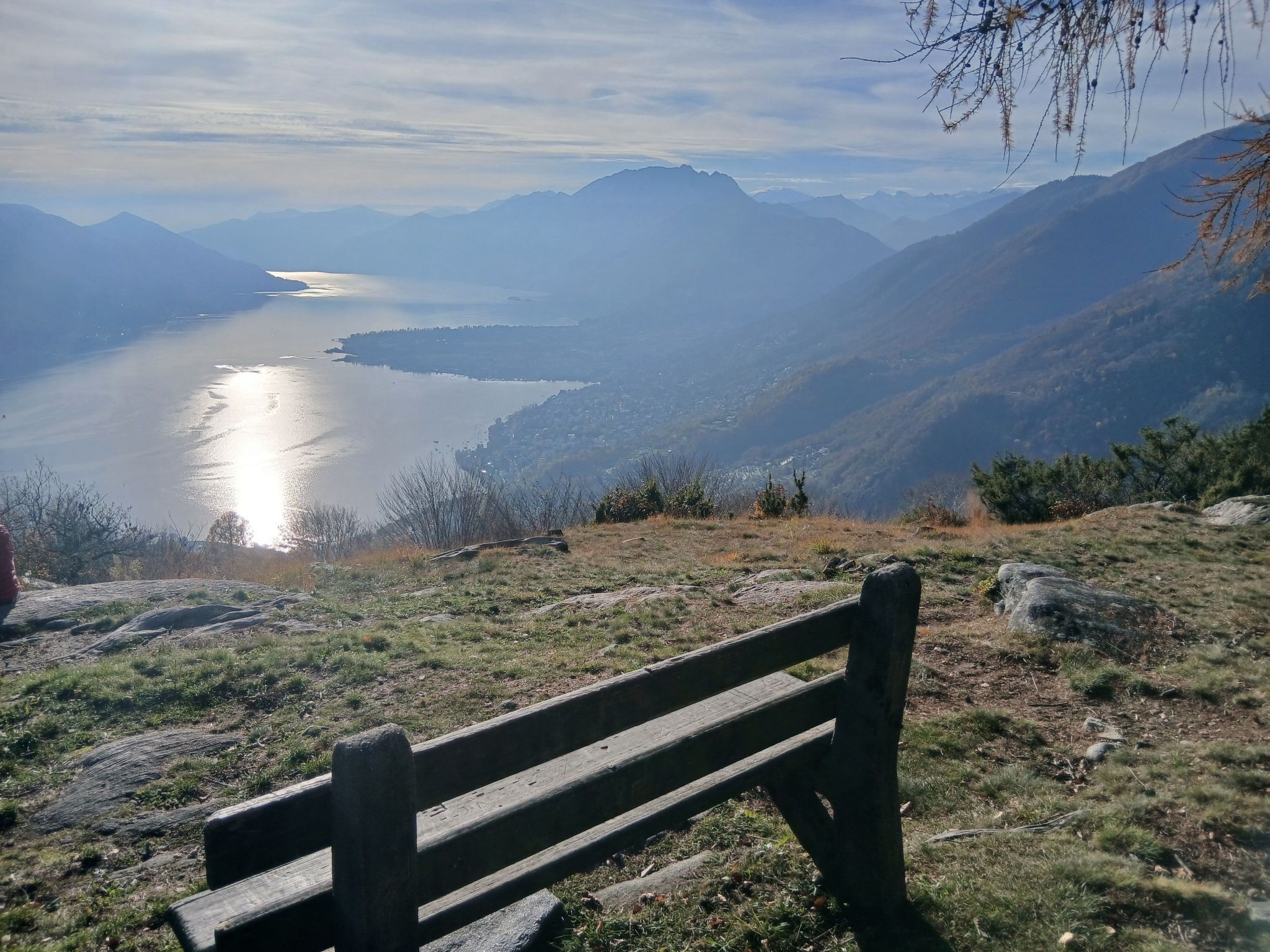 A bench overlooking a lake with mountains in the background.