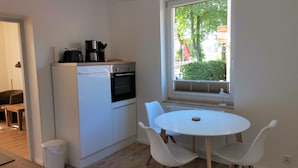 Eine kompakte Küche mit Einbauofen und einem Fenster mit Außenblick.