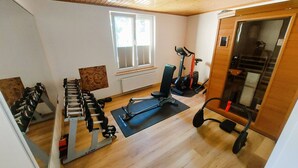 A gym with exercise equipment, a window, and wooden flooring. - Vacation home  by Interhome (Bansin)