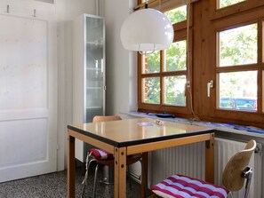 A room with a wooden table, a chair, a radiator, and a window with a view of trees. - Zentrale Wohnung mit Klavier, Kunst und Design by Interhome (Bremerhaven)