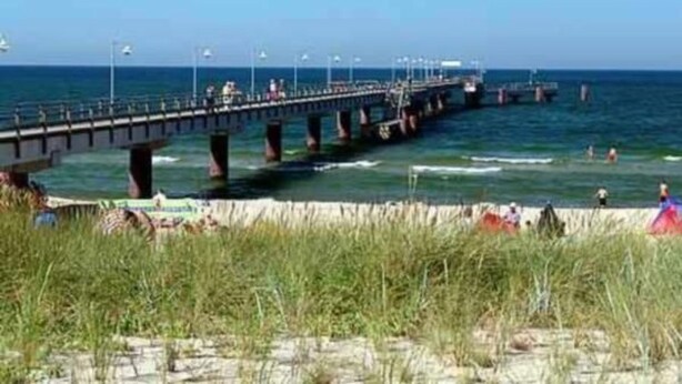 A pier extending into the sea with people walking and standing on it. - Villa Granitz by Interhome (Baabe)