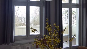 A room with large windows, a radiator, and a vase with yellow flowers. - Villa Granitz by Interhome (Baabe)