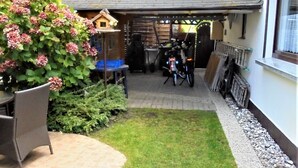 Un espacio de patio cubierto con una bicicleta, una mesa y una silla.