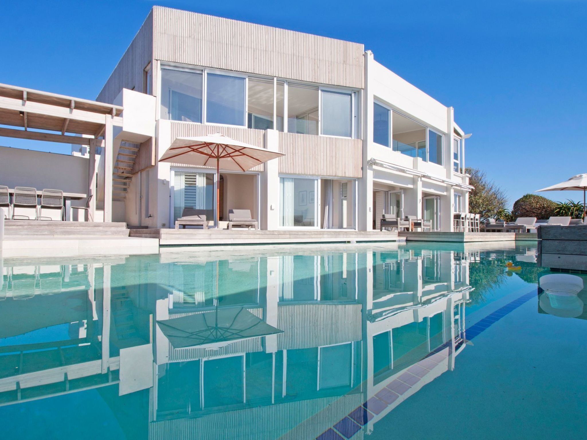 Un bâtiment moderne à deux étages avec une piscine à l’avant.