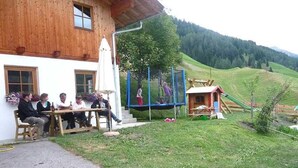 Un bâtiment en bois doté d’une terrasse où des personnes sont assises.
