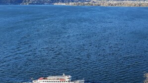 Una barca su un lago con montagne sullo sfondo.