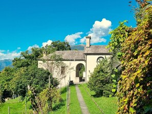 Ein traditionelles Gebäude mit einem Stehdach, einem Bogenportal und einem Weg, der davorhin führt.