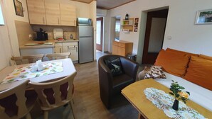 A compact living space with a kitchenette, a dining area, and a sofa. - Vacation home Elster by Interhome (Frielendorf)
