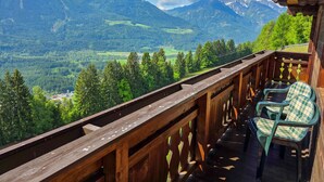 Ein Holzbalkon mit Blick auf eine gebirgige Landschaft.