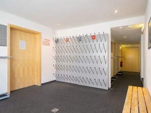 Ein Flur mit einem an der Wand befestigten Kleiderhaken, einer Holztür und einem Feuerlöscher.
