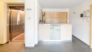 Una cocina moderna con una isla central, lavavajillas integrado y armarios de madera.
