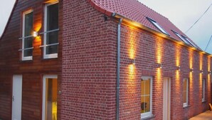 A two-story brick house with a sloped roof, large windows, and a wooden deck. - Komplett neue ländliche Unterkunft im Cottage-Stil Komfort by Interhome (Ellezelles)