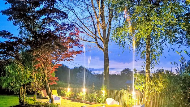 A garden with a seating area, a pathway, and a bamboo fence. - Komplett neue ländliche Unterkunft im Cottage-Stil Komfort by Interhome (Ellezelles)