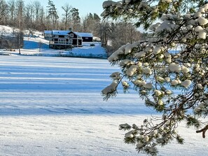 A snow-covered landscape with a house and trees. - Hjorted am Seeufer by Interhome (Hjorted)