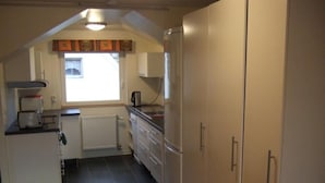 A compact kitchen with a refrigerator, a toaster, and a window with curtains. - mit Blick auf das Wasser by Interhome (Helsingborg)