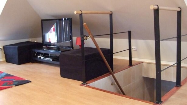 A room with a TV, black furniture, and a wooden structure. - mit Blick auf das Wasser by Interhome (Helsingborg)