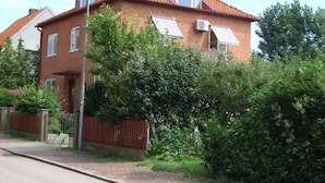 A two-story brick house with a red roof, white window shutters, and a small attached garage. - mit Blick auf das Wasser by Interhome (Helsingborg)
