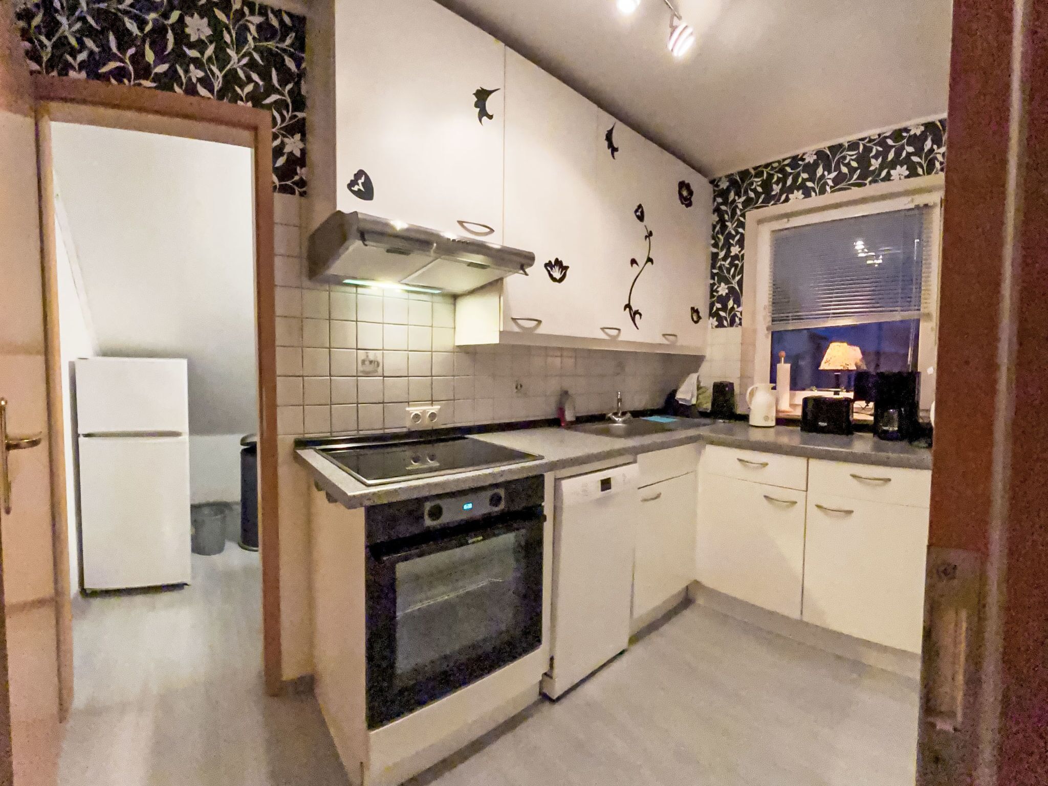 A kitchen with white cabinets, a stove, and a sink.