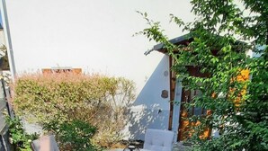 A round outdoor table with six wooden chairs, surrounded by a paved patio area with stone tiles. - Festung zu Ketghe by Interhome (Kettig)
