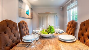 A dining table set with plates, glasses, and cutlery, surrounded by upholstered chairs. - Horstweg in Westerland by Interhome (Archsum)