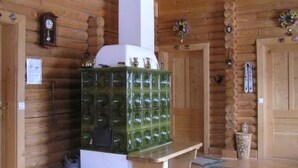 A wooden interior with a green cabinet, a clock, and a door with a floral decoration.