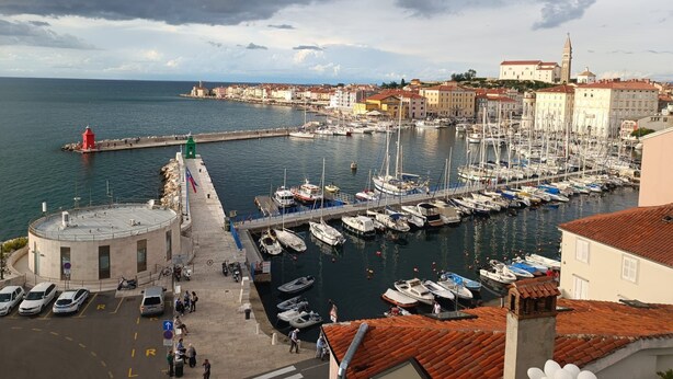 Un port avec des bateaux, un phare et des bâtiments le long de la rive.