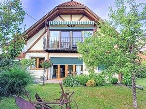 Ein zweistöckiges Haus mit Balkon, Garage und einem gepflegten Garten.