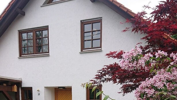 A two-story house with a white exterior, a wooden door, and a small porch with steps leading to the entrance. - Apartment Grete by Interhome (Erfurt)