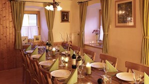 A dining area with a wooden table set for a meal, featuring plates, glasses, and candles. - Chalet Gove für Unterkunft mit Halbpension unter der Leitung des Eigentümers by Interhome (Tamsweg im Lungau)