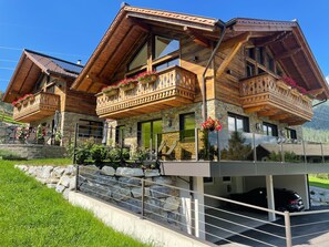 A chalet with wooden balconies, stone walls, and a carport. - Edelstein by Interhome (Forstau)