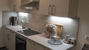 Una cucina moderna con elettrodomestici in acciaio inossidabile, forno integrato e piano di lavoro in legno.