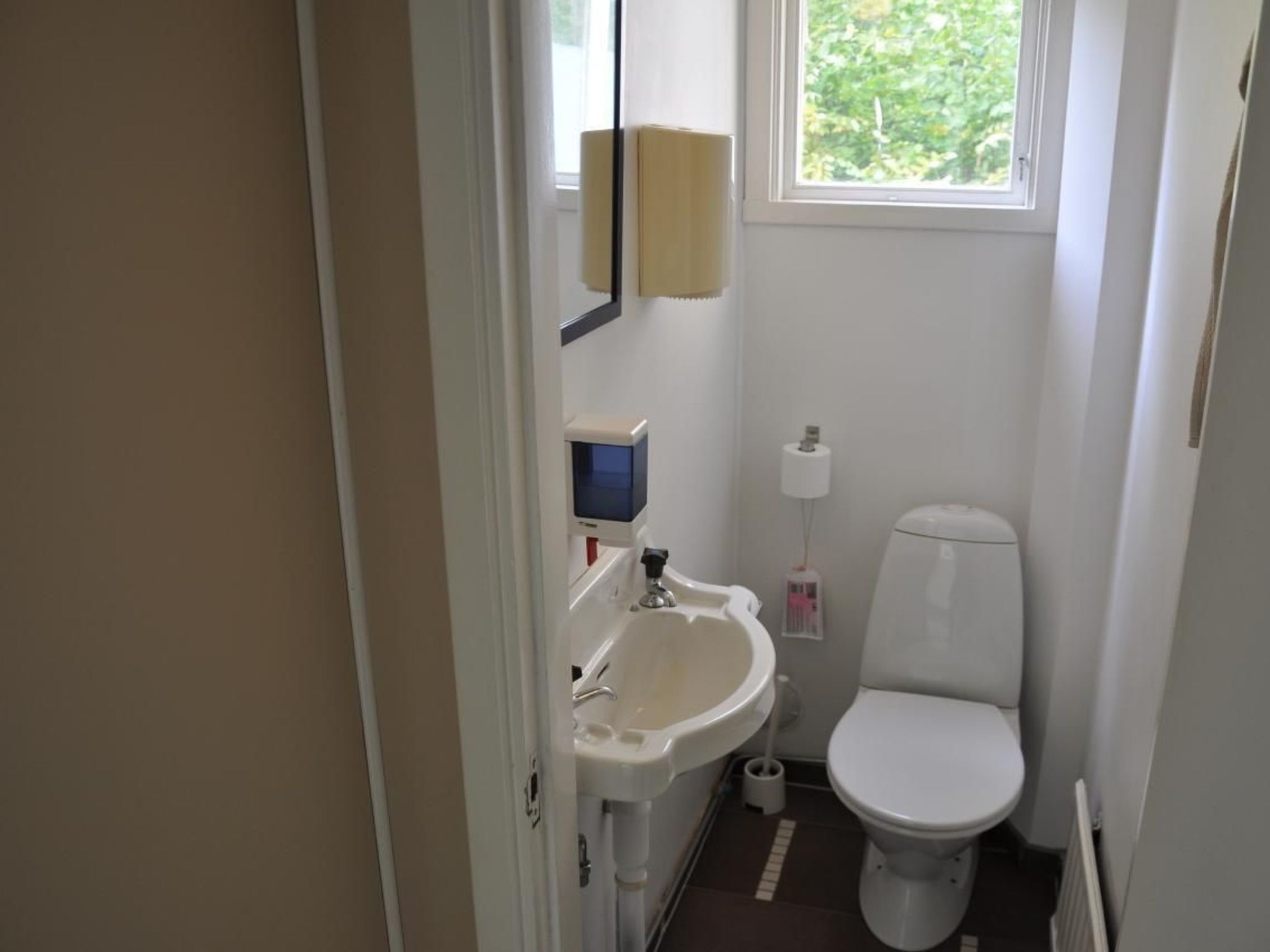 Un bagno piccolo e funzionale, con il water, un lavabo e uno specchio.