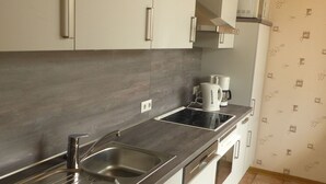 Eine moderne Küche mit Edelstahlgeräten, einer doppelten Spüle und einem eingebauten Backofen.