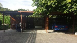 Un espace de stationnement couvert avec une voiture et un vélo.
