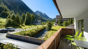 Ein Balkon mit Blick auf einen Berg, einen Fluss und eine Straße mit Autos.