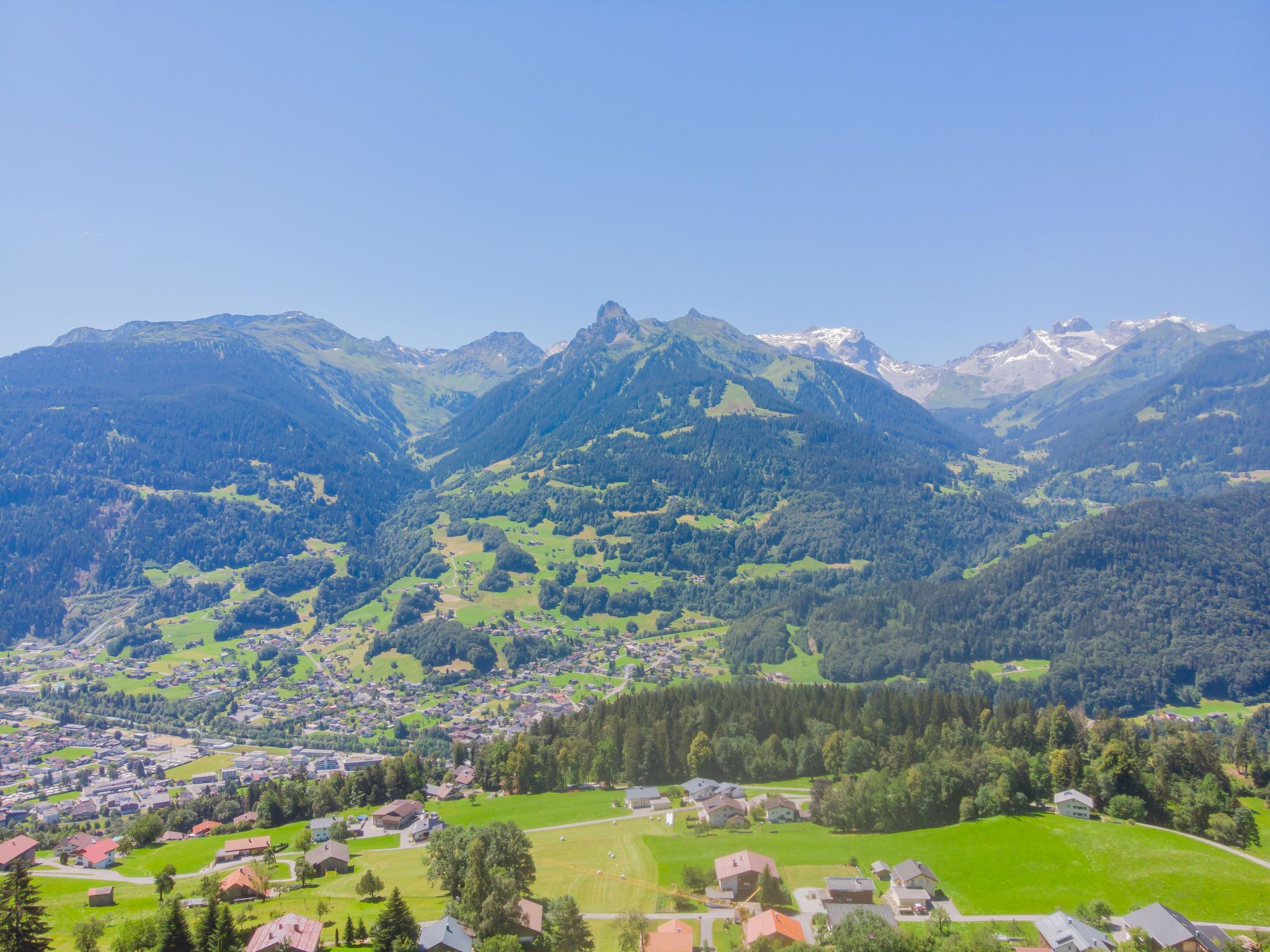 Eine gebirgige Landschaft mit einem Dorf, eingebettet in ein Tal.