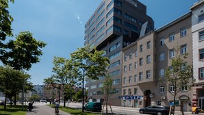 A modern urban street with buildings, a bike lane, and pedestrians. - Skyflats Hills View by Interhome (Vienna)