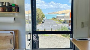 A compact kitchen with a window view of a road and buildings.
