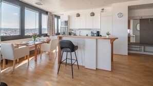 Cocina moderna con una isla central, ventanas amplias y vistas a la ciudad.