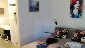 Un dormitorio con cama, un cuadro y el letrero de un baño.