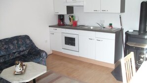 A compact kitchen with white cabinets, a built-in oven, a sink, and a stove. - in ruhiger Lage am Waldrand by Interhome (Navis)