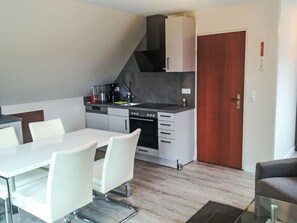 A modern kitchen with a dining area, including a table and chairs. - Körner Kornhof7 1.OG by Interhome (Dahme)