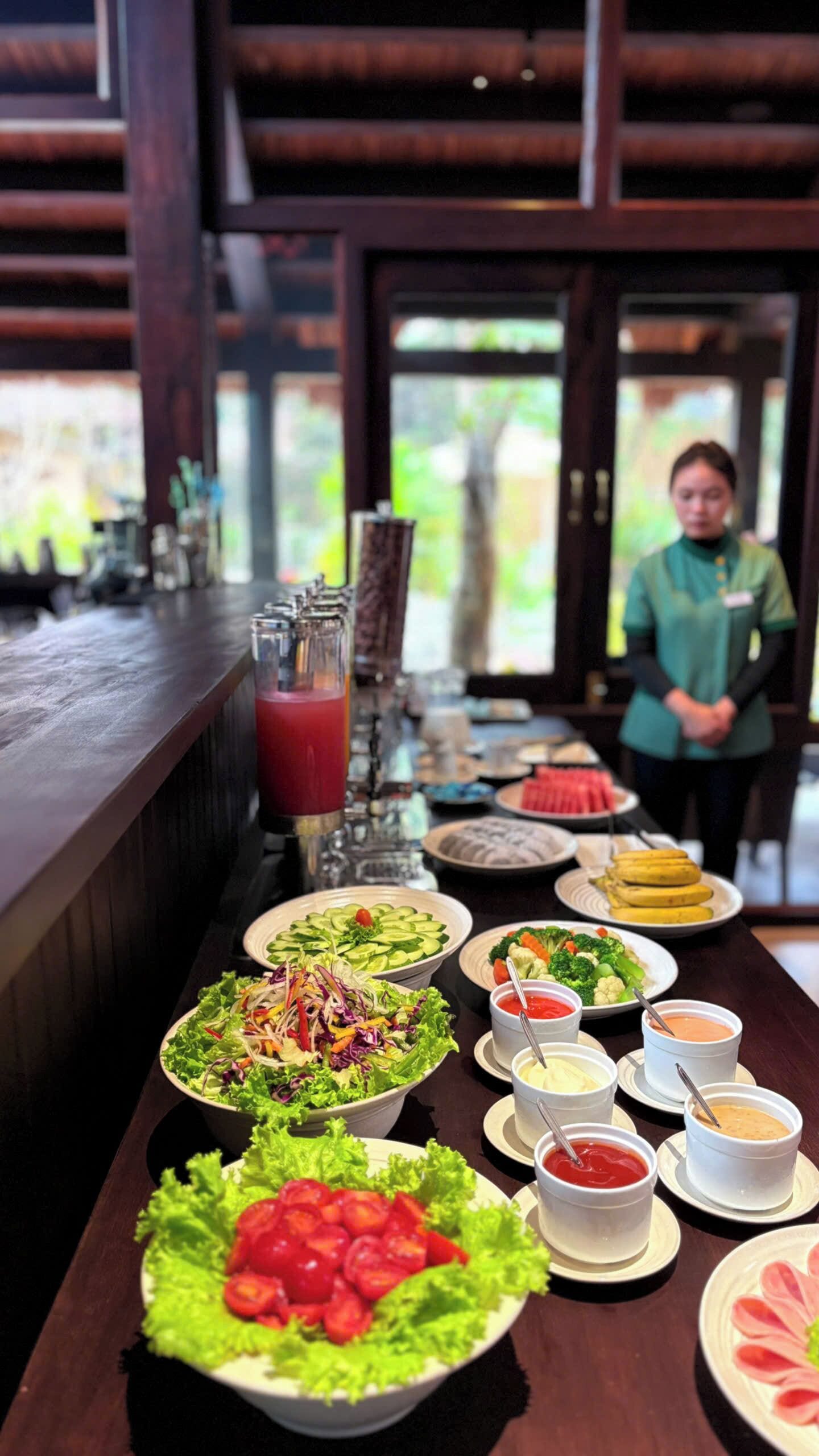 Een buffettafel met verschillende gerechten, waaronder salades, fruit en dipsauzen.